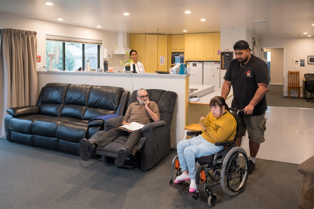 a person wheelchair and another person sitting in an armchair